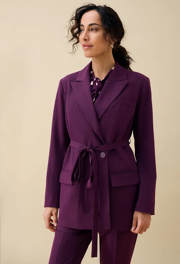 Elegant, fiolett blazer med belte og matchende bukse, kombinert med prikkete bluse.