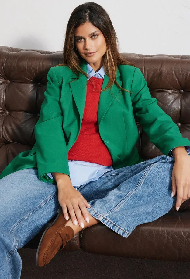 Gr&oslash;nn blazer, r&oslash;d topp, bl&aring; skjorte, vide jeans og brune sko.