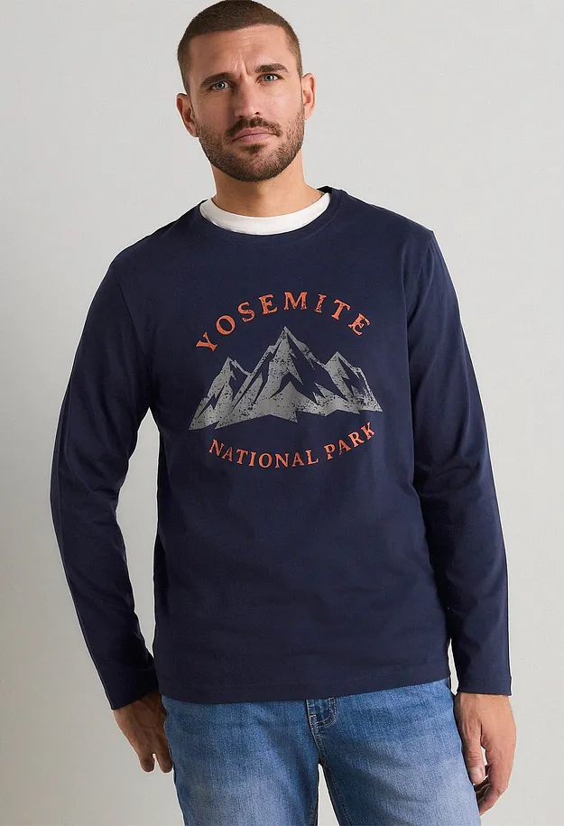 M&oslash;rkebl&aring;, langermet overdel med Yosemite-trykk og jeans gir en avslappet stil.