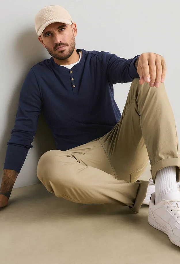 Beige caps, bl&aring; bestefartr&oslash;ye, beige bukse og hvite sneakers.