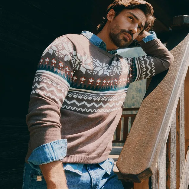 Hen i m&oslash;nstret genser over skjorte i denim og bl&aring; jeans.