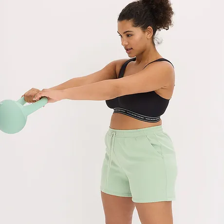 Sort treningstopp med logobånd kombinert med mintgrønne shorts – en fresh treningslook.