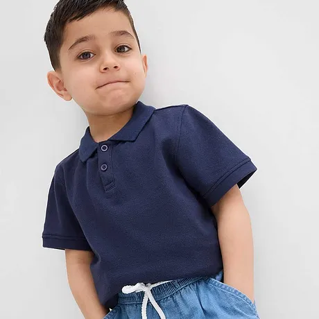 En mørkeblå poloskjorte kombinert med lyseblå jeans.