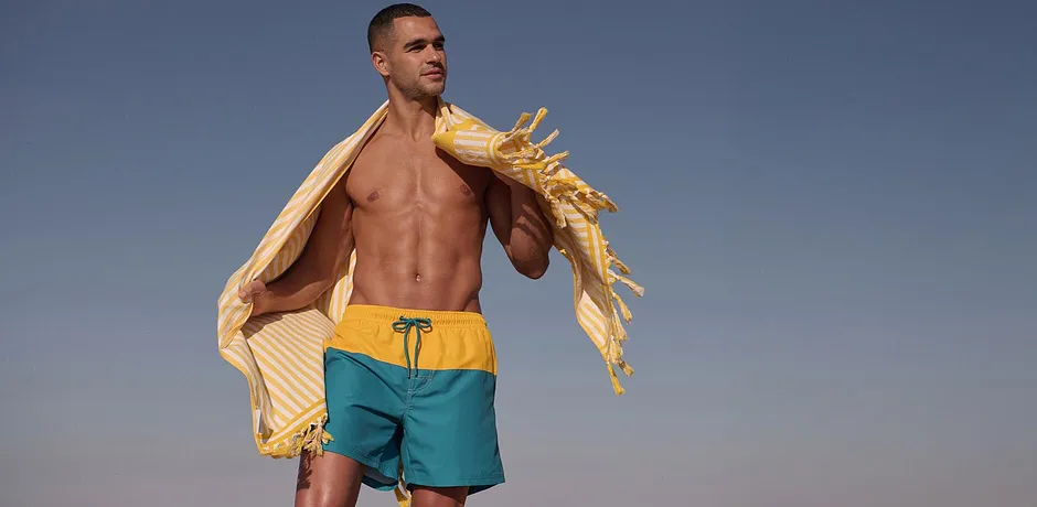 Sommerlig strandmote: Turkis badeshorts for solfylte dager.