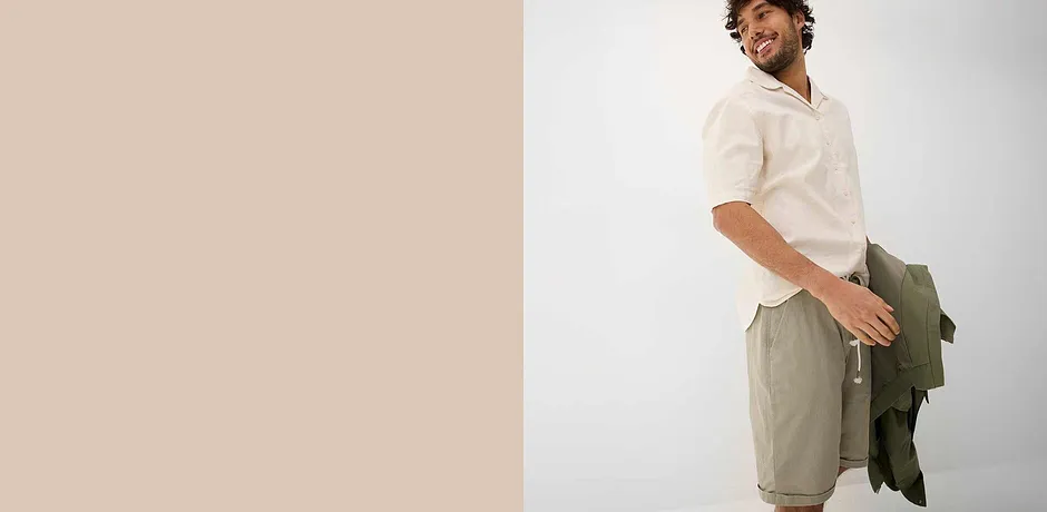 Lett, hvit skjorte, beige shorts og grønn jakke for en avslappet sommerlook.