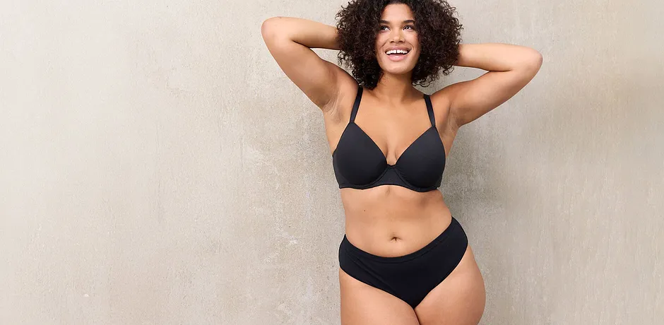 Sort bikini fremhever den selvbevisste kvinnens naturlige skjønnhet og former.