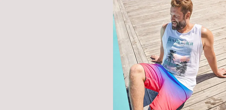 Hvit singlett og badeshorts i friske rosa- og blåtoner til strand og basseng.