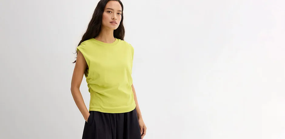 En flott limefarget topp kombinert med et mørkt skjørt i lett materiale.
