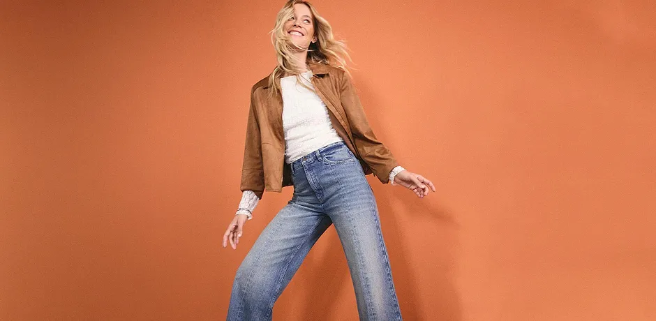 Casual look: Brun skinnjakke, hvit topp og vide jeans for en avslappet stil.