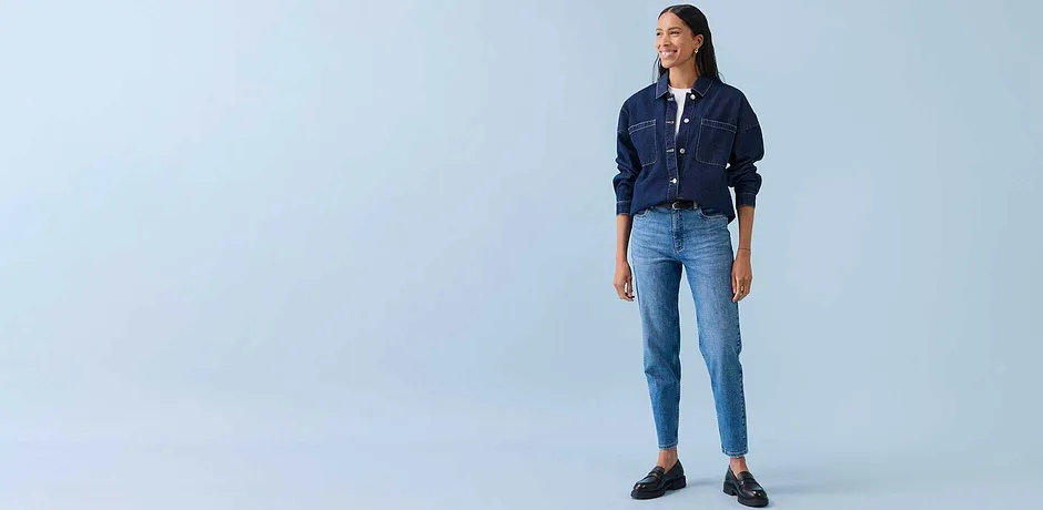 Ledig look med denimjakke, hvit skjorte og lyseblå jeans. Mørke sko fullfører antrekket.