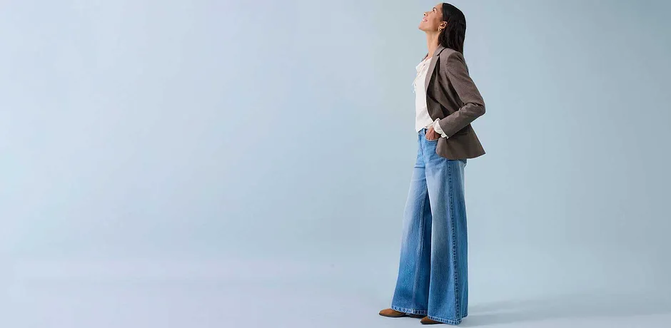 Vide jeans, lys topp og beige blazer skaper en avslappet stil.