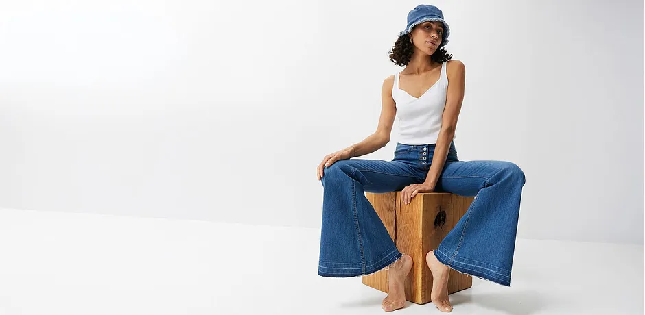 Vide jeans, hvit topp og blå caps: en avslappet sommerlook for varme dager.