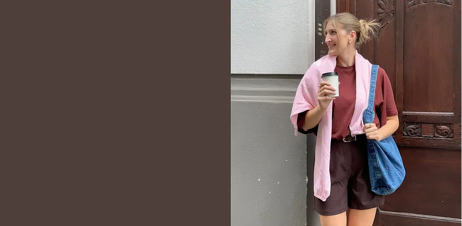 Sommerantrekk med rosa cardigan, brun shorts og blå veske.