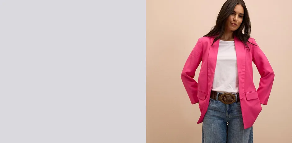 Knall pink blazer over en hvit T-skjorte kombinert med klassisk bluejeans og brunt belte.