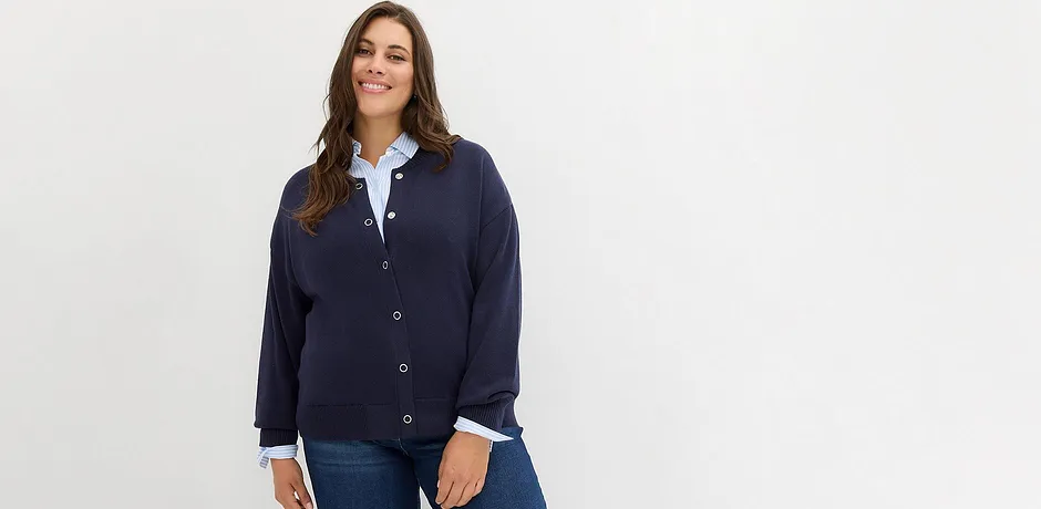 Mørkeblå cardigan over hvit skjorte kombinert med klassiske jeans.
