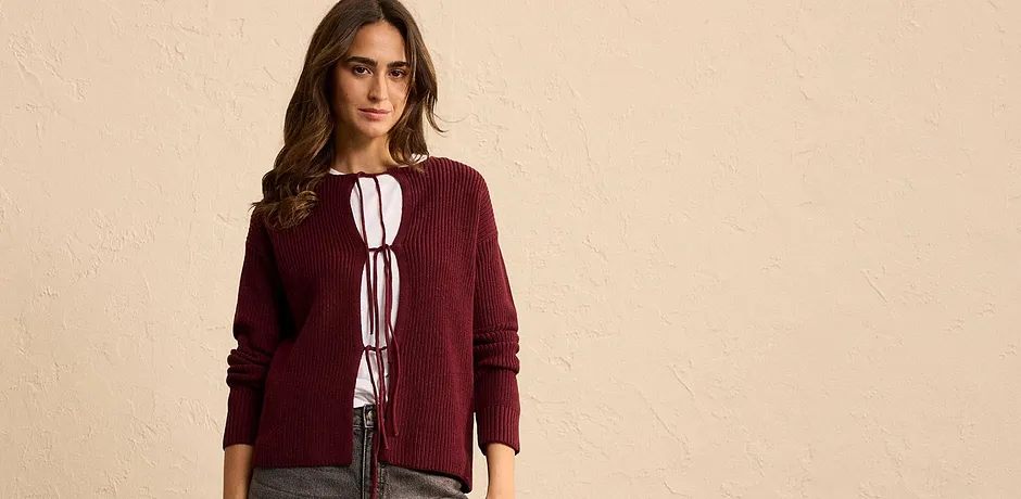 Burgunder cardigan med knyting over hvit bluse.