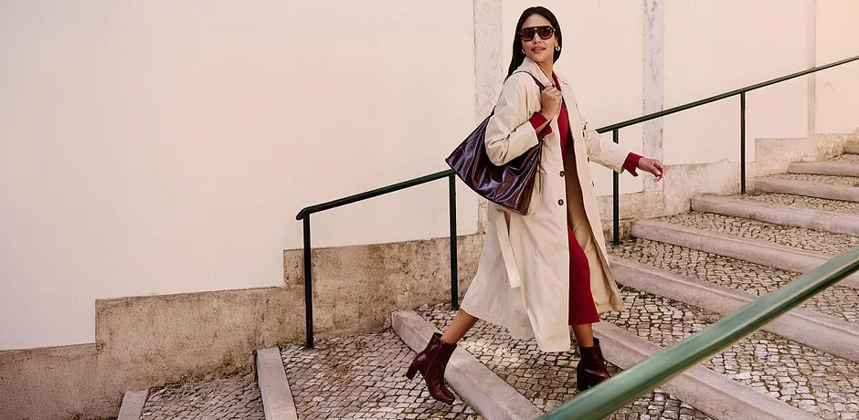 Elegant trenchcoat, røde aksenter, statement-ankelstøvletter. Stilfull kombinasjon for en urban look.