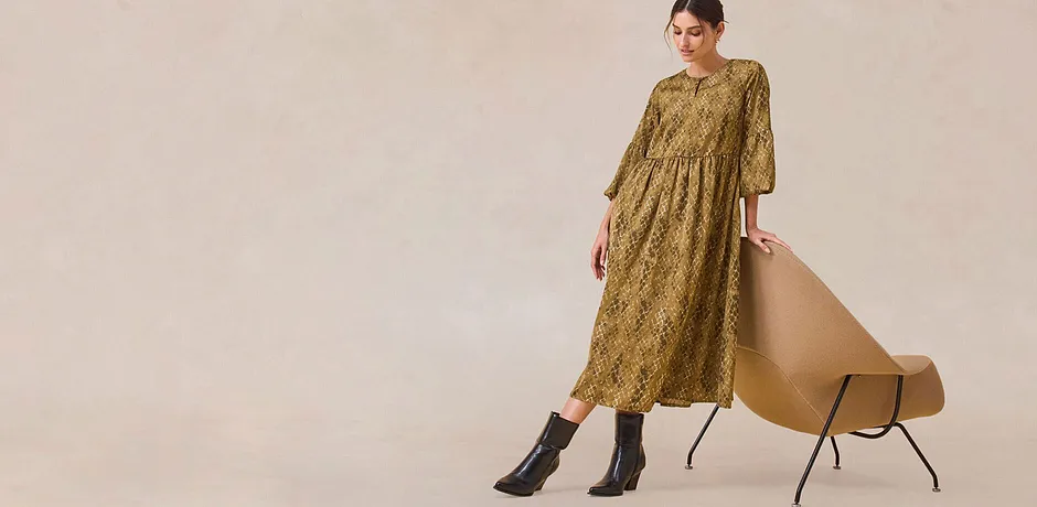 Elegant, grønn kjole med lange ermer.