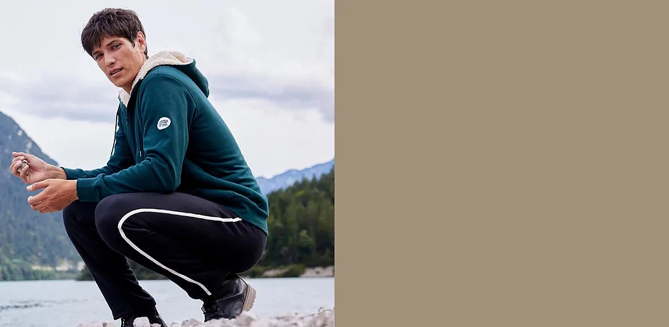 Grønn sweatjakke og sort joggebukse for aktive utendørsaktiviteter.