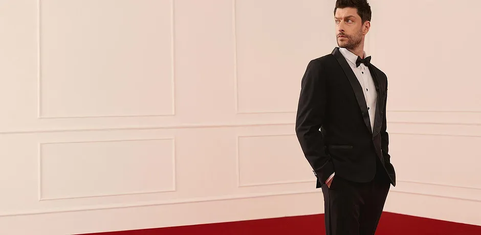 Elegant, sort smoking med hvit skjorte og tversoversløyfe for festlige anledninger.