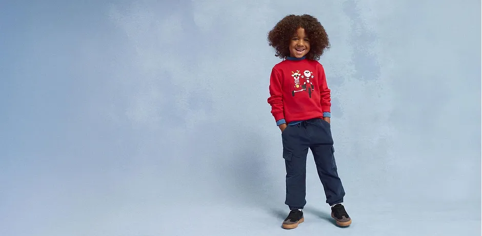 Rød julegenser, bluejeans og brune sko.