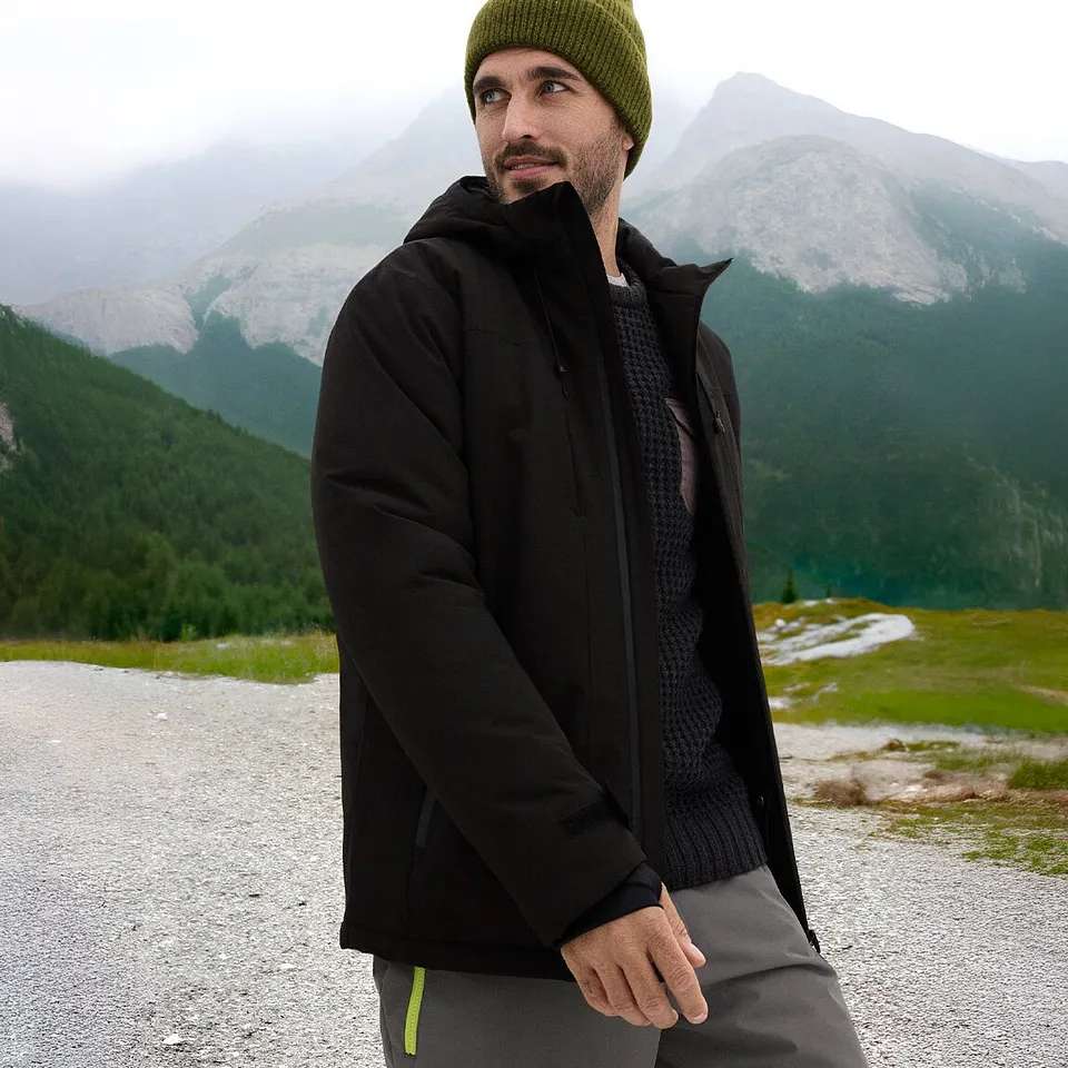 Sort jakke og grønn lue for en perfekt vinterlook.