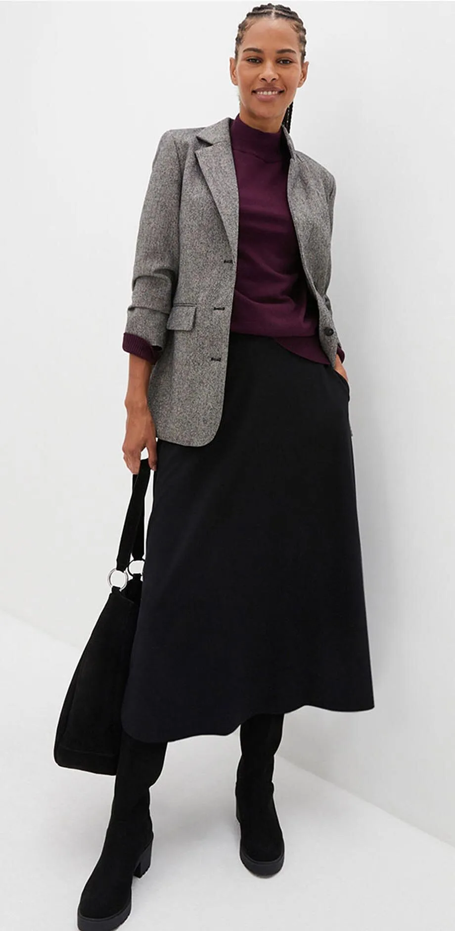 Rutete blazer, fiolett topp og langt, sort skjørt.