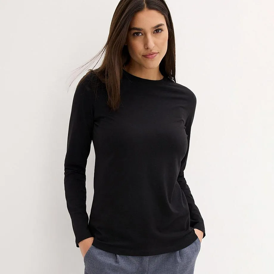 Stilren, sort topp med lange ermer.