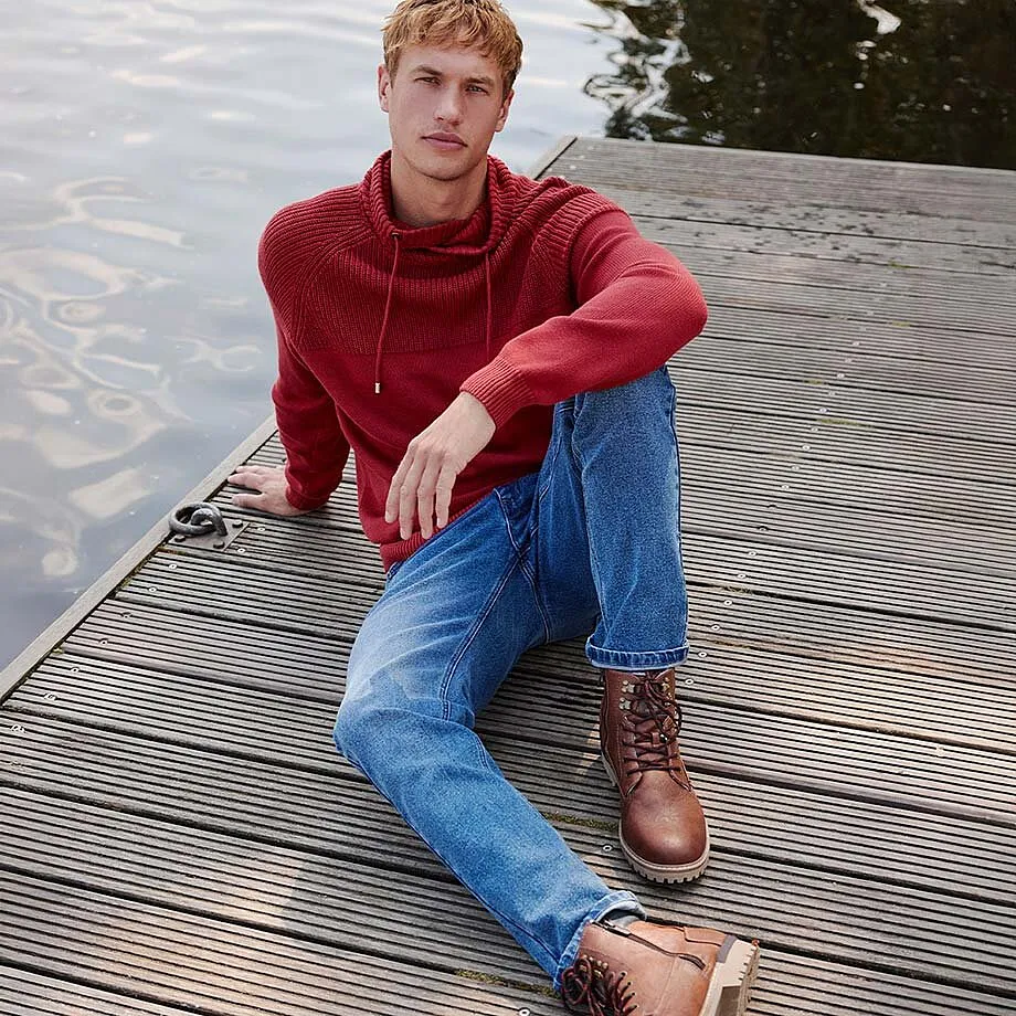 R&oslash;d hettegenser m&oslash;ter bluejeans og brune skoletter i skinn.