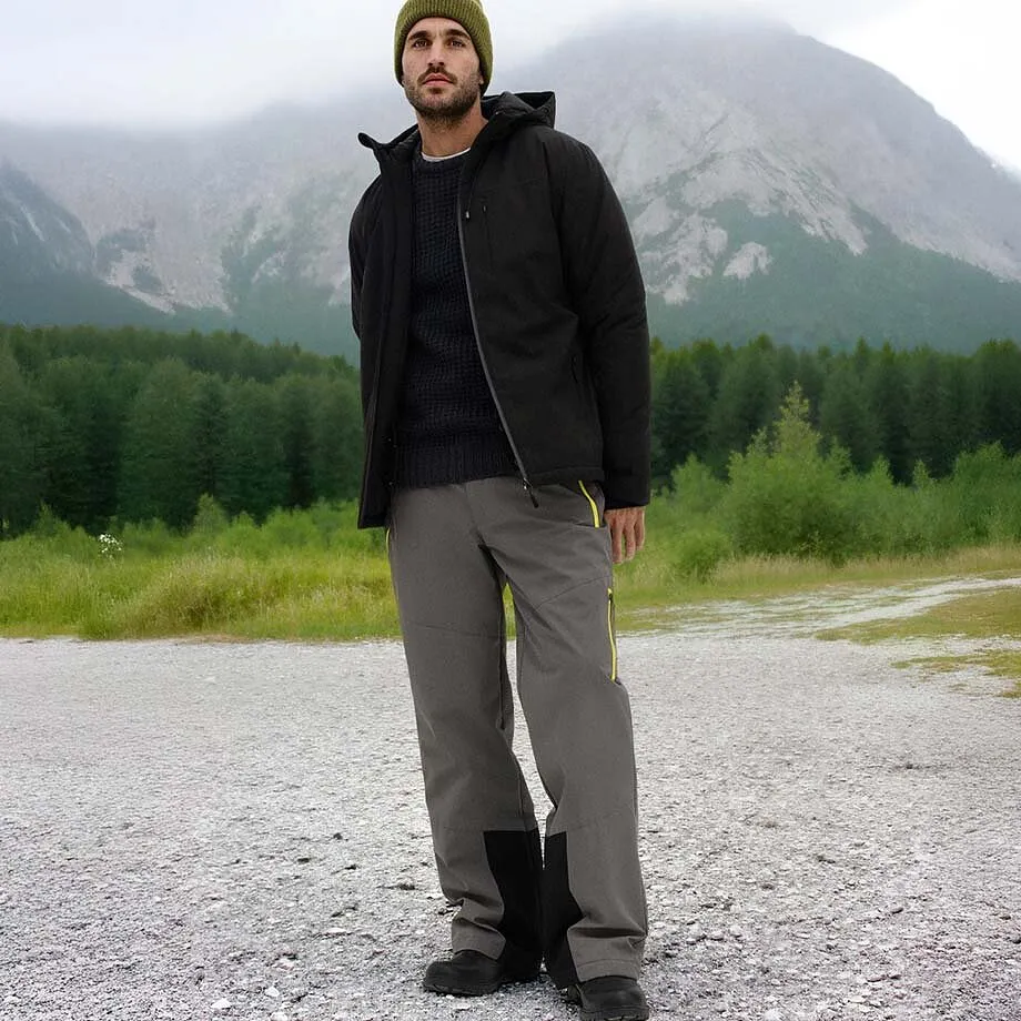 M&oslash;rk vinterjakke, gr&aring; bukse og gr&oslash;nn lue.