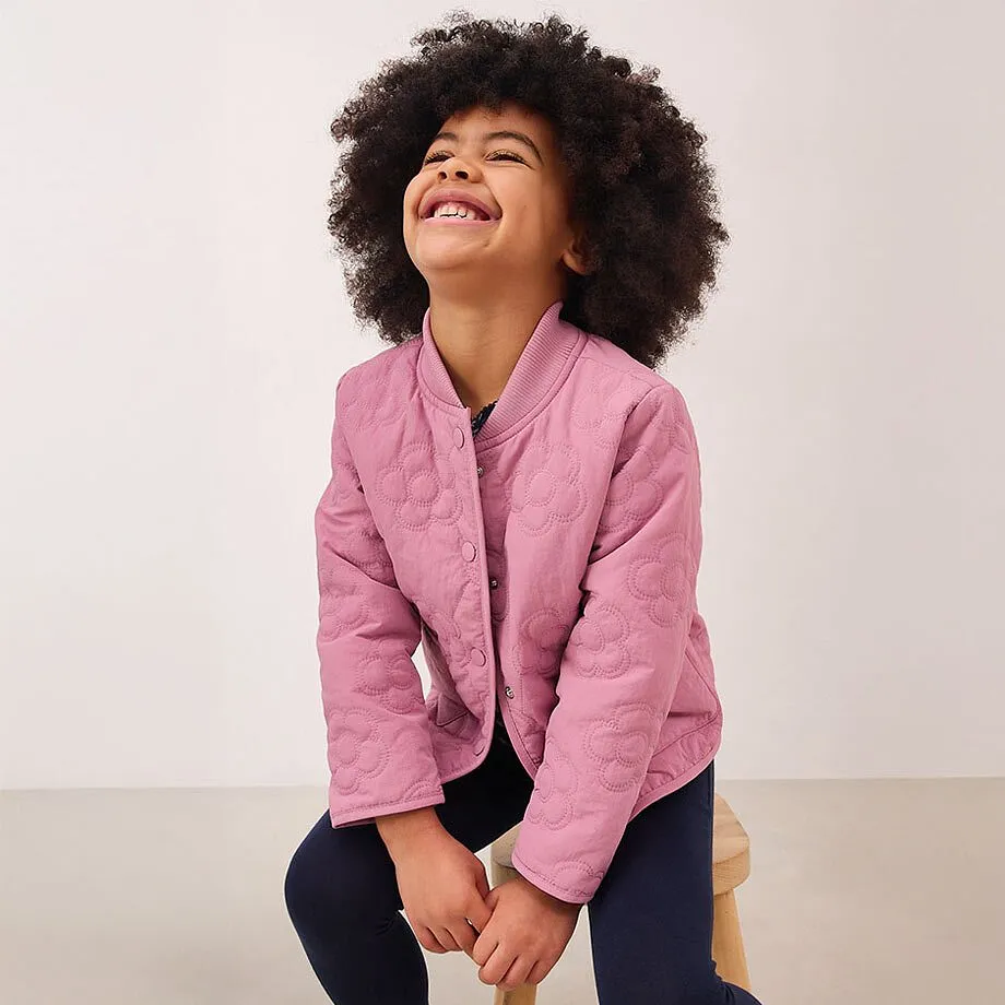 Rosa jakke med knapper over m&oslash;rk topp.