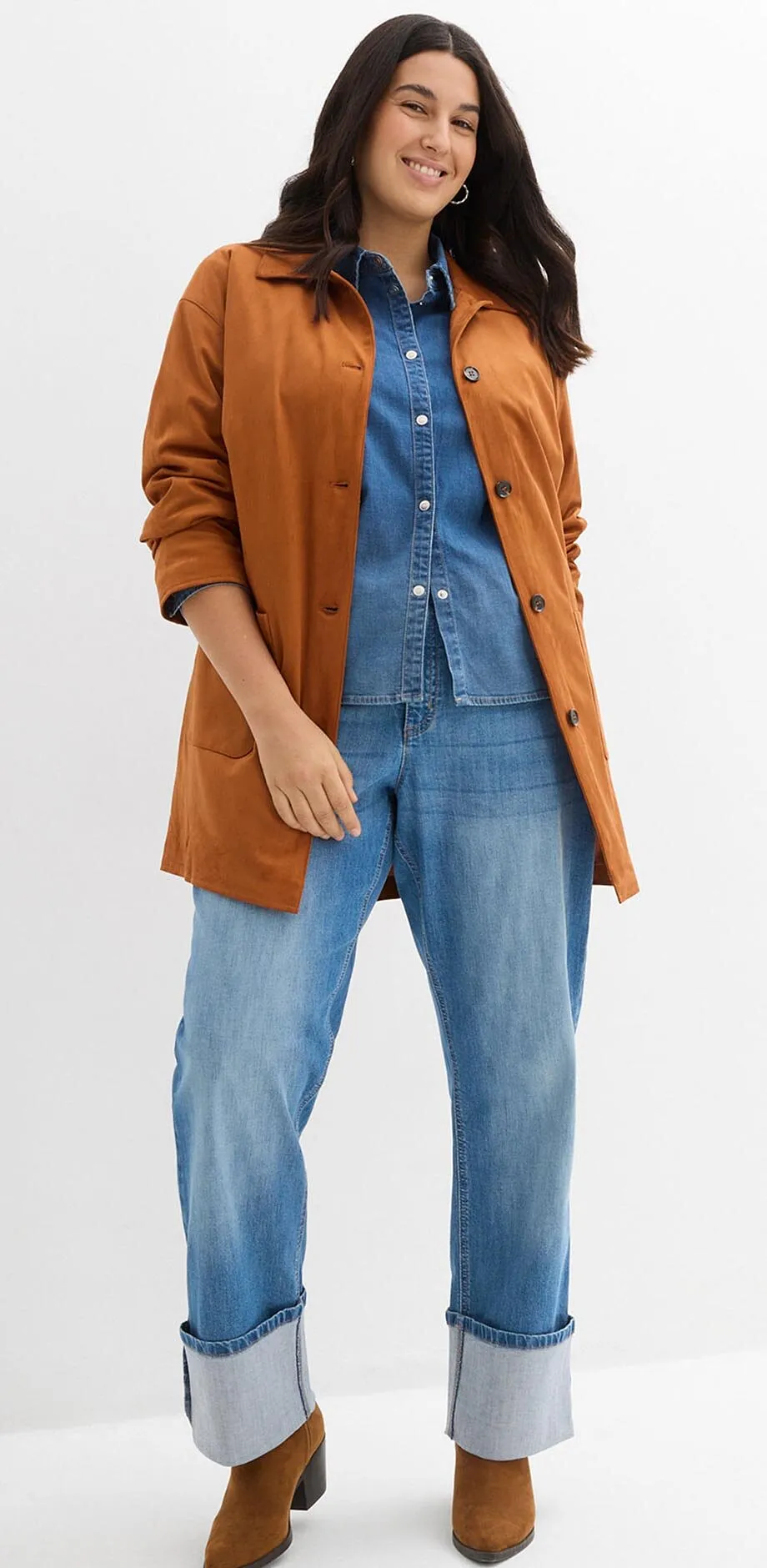 Brun jakke over denimskjorte og vide jeans med oppbrett.