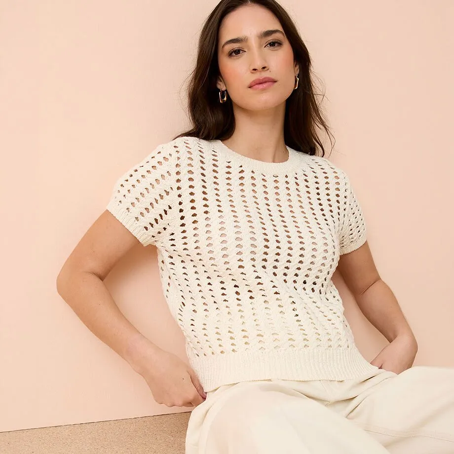 Hvit genser med hullm&oslash;nster og korte ermer samt rund hals.