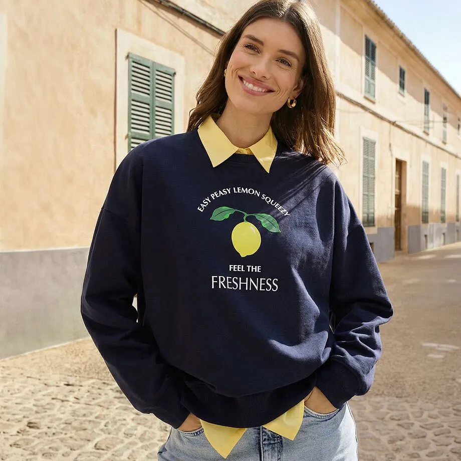 M&oslash;rkebl&aring; genser med gul krage og sitrontrykk.