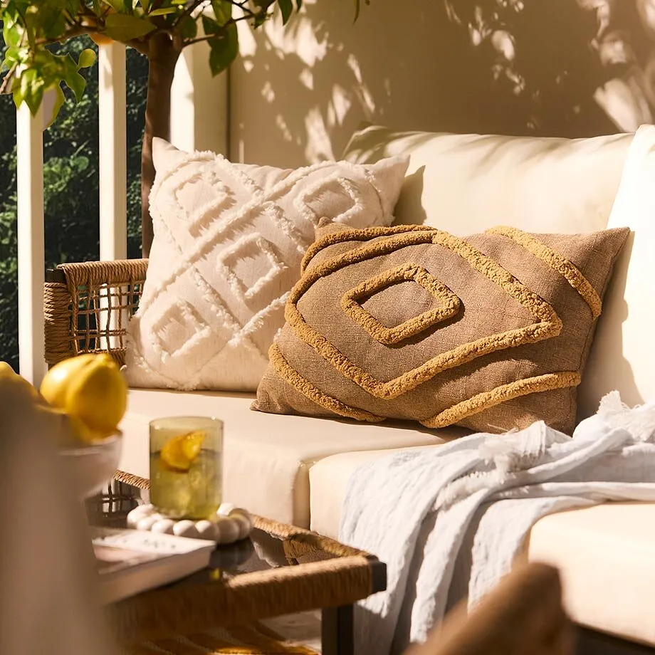 Behagelige loungem&oslash;bler med lyse puter og mykt pledd.