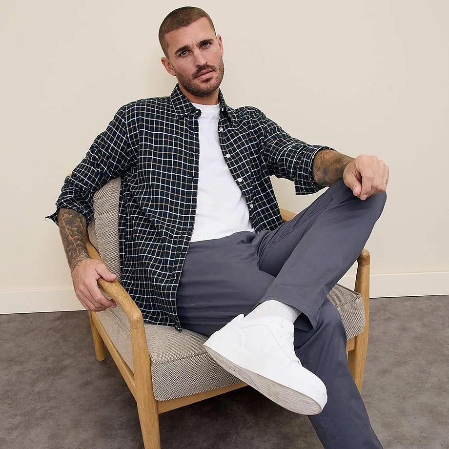 Rutete skjorte over hvit T-skjorte, gr&aring; bukse og hvite sneakers. Avslappet, moderne stil.