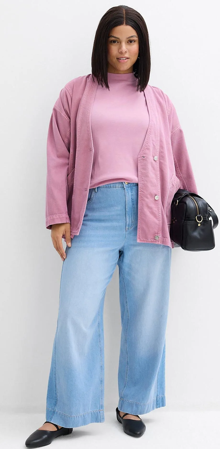 Rosa cardigan over pastellrosa topp kombinert med lysebl&aring; jeans og sorte sko.