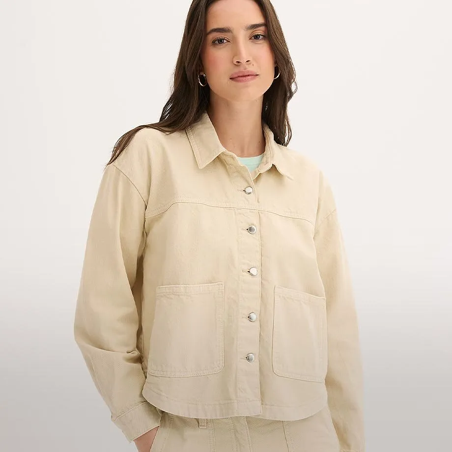 Kremfarget jakke med krage, knapper og brystlomme.