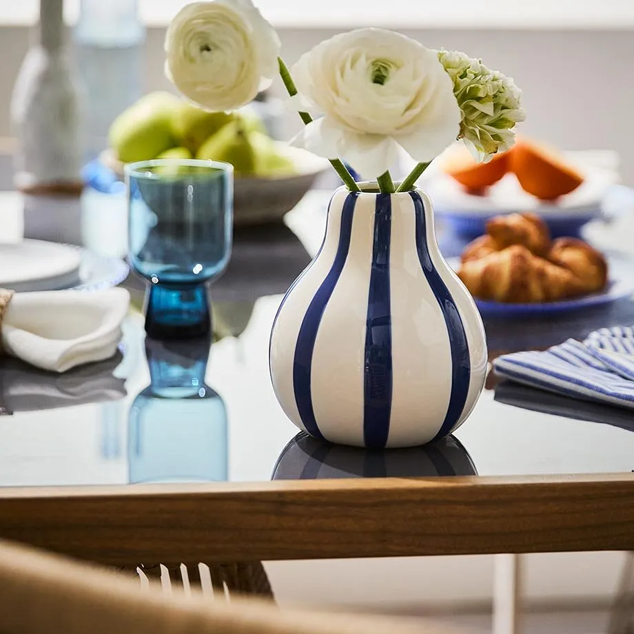 En stripete vase med hvite blomster.