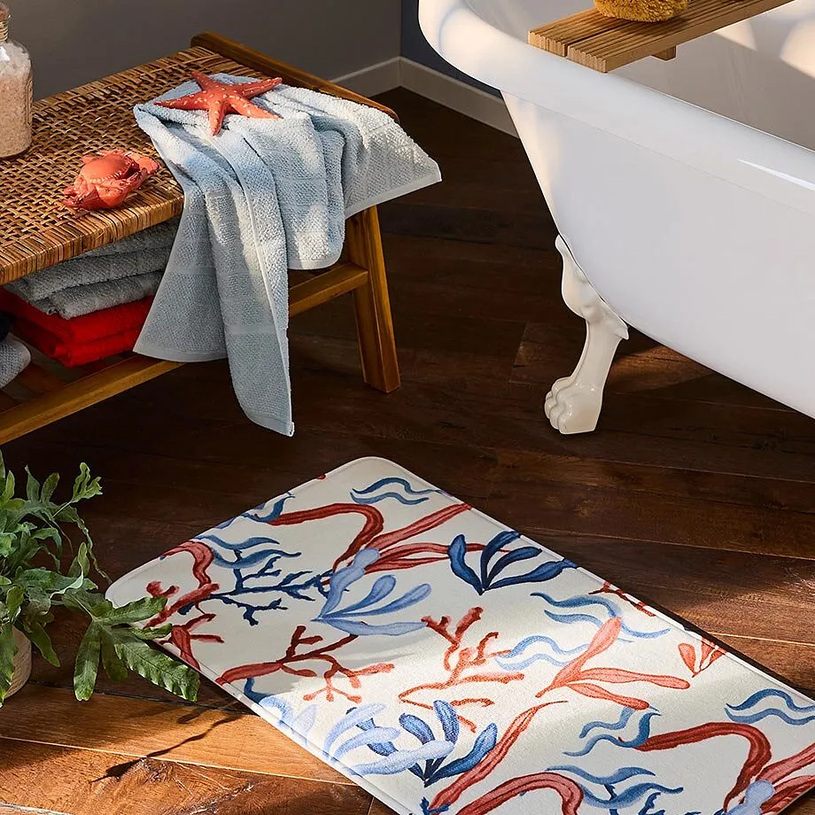 Et lysebl&aring;tt h&aring;ndkle ligger p&aring; en trebenk ved siden av et frittst&aring;ende badekar.