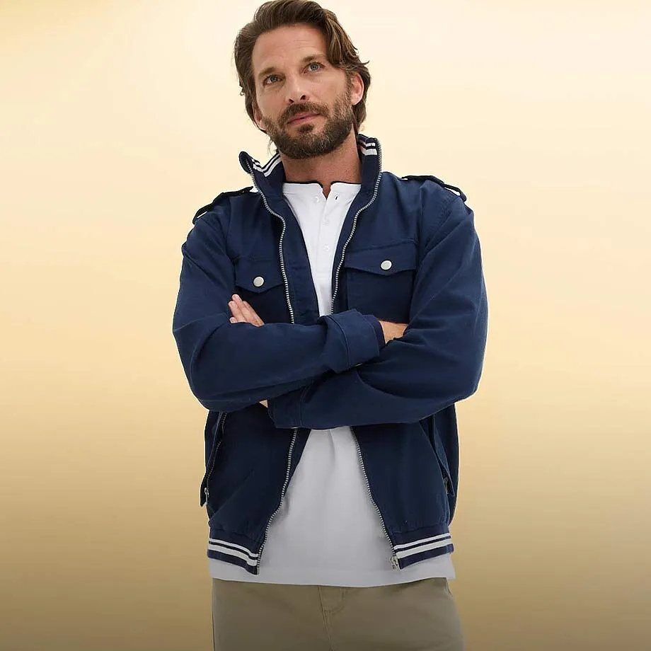 M&oslash;rkebl&aring; jakke med hvite detaljer over en stilren, hvit shirt.