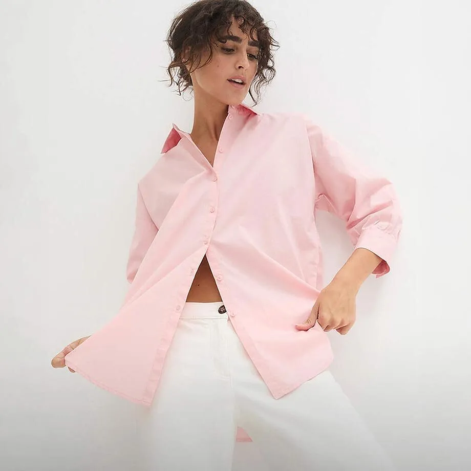 Blek rosa skjorte over hvit bukse.