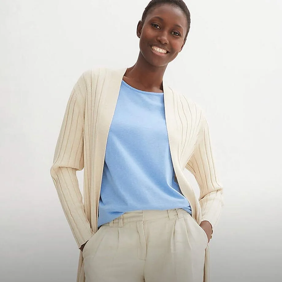 Kremfarget cardigan over lysebl&aring; topp kombinert med lys dressbukse.