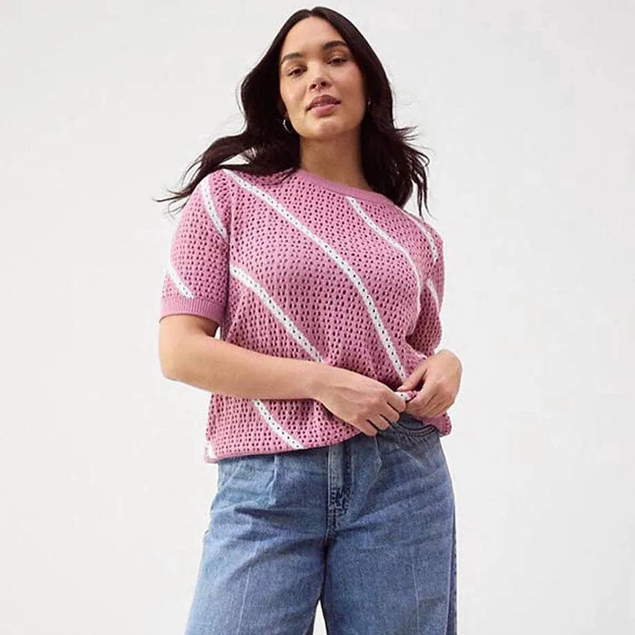 Avslappet, rosa genser kombinert med vide jeans.