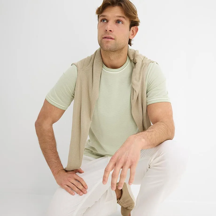 Lys T-skjorte kombinert med lett genser og hvit bukse.