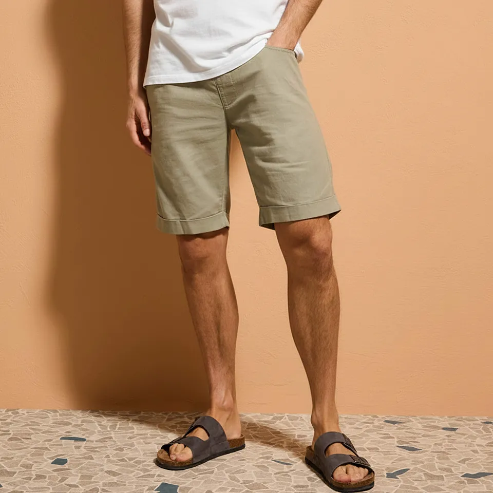 Hvit T-skjorte, beige shorts og behagelige, brune sandaler.
