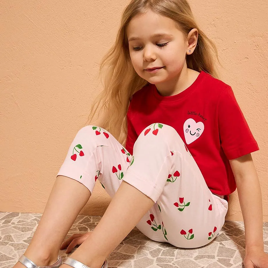 Lite barn i r&oslash;d T-skjorte med hjertemotiv.