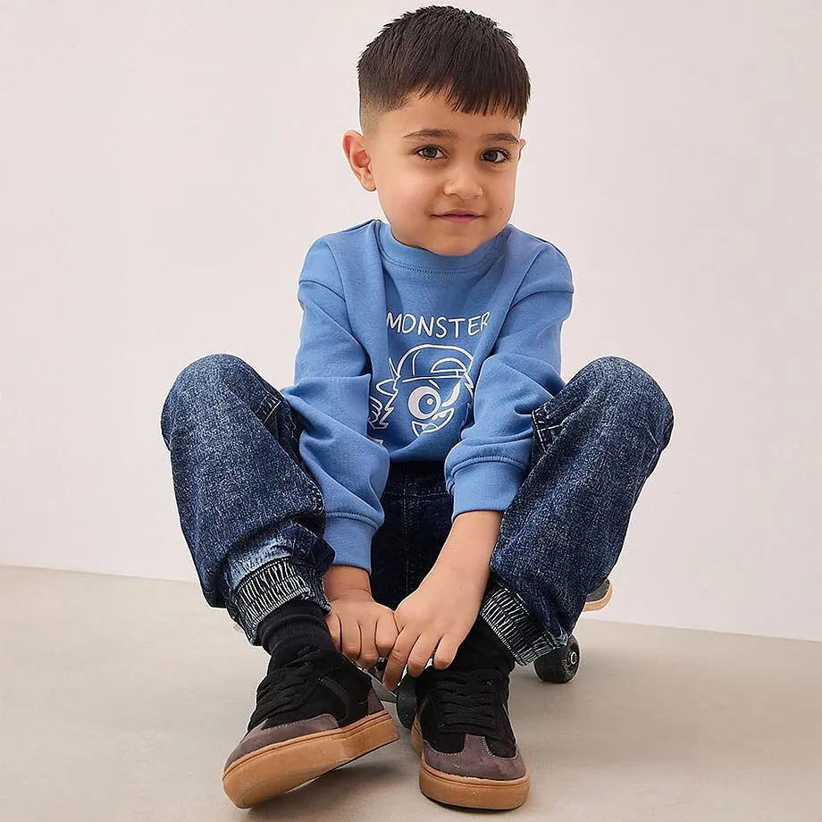 Lite barn sitter p&aring; gulvet.