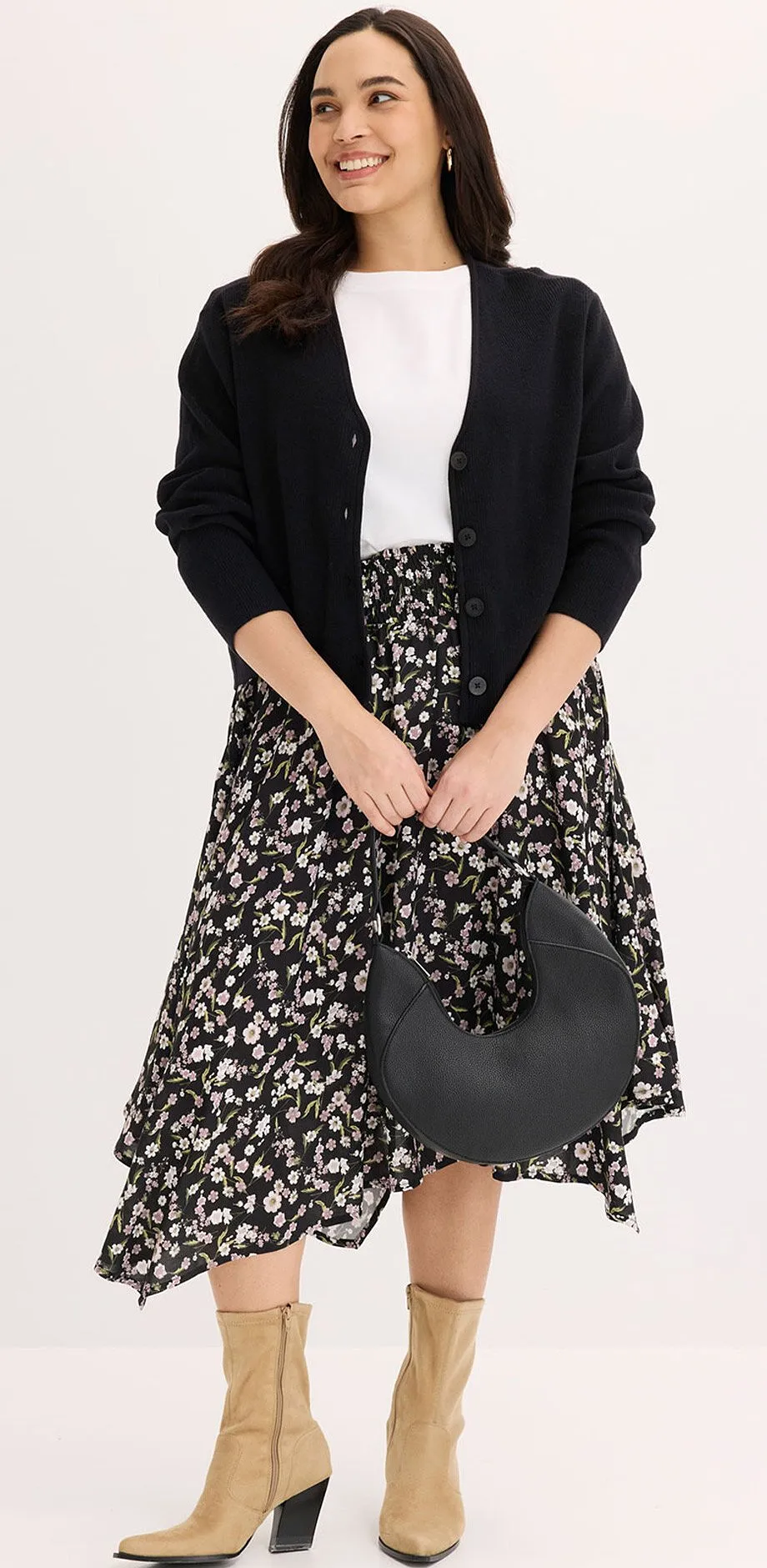 Sort cardigan, hvit topp og sort og hvitt m&oslash;nstret midiskj&oslash;rt.