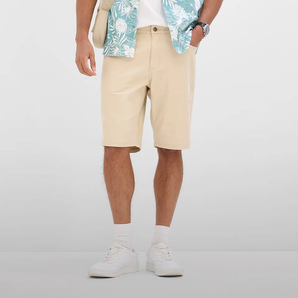 Coolt sommerantrekk med beige bermudashorts, m&oslash;nstret skjorte og hvite sneakers.